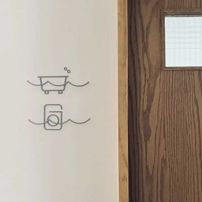 「BATHROOM / LAUNDRY」水のうねうねが特徴的なお風呂・洗濯機のサイン。