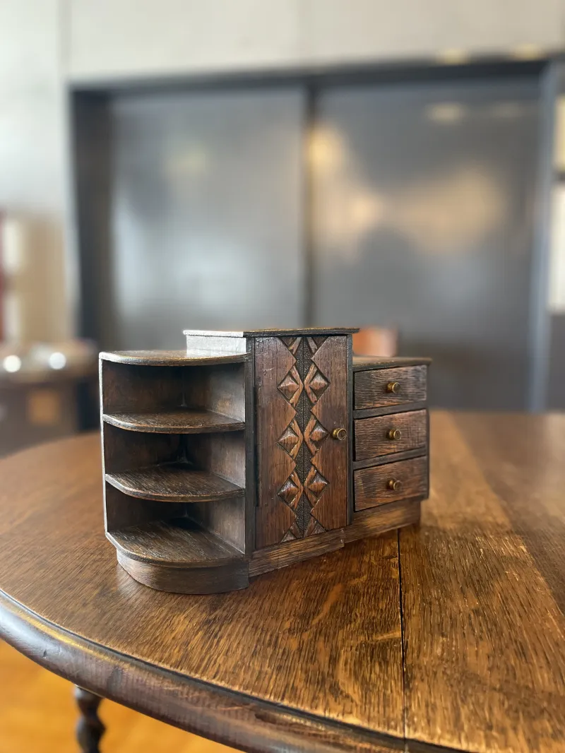 幾何学模様の彫刻が施された小引き出しと棚を組み合わされたミニチュア木製家具