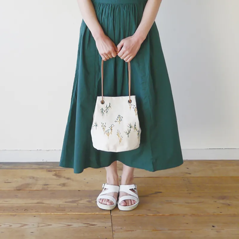 広島・尾道でつくられた帆布生地に、手刺繍のようなやわらかいステッチを全面にほどこした「森のバケツポシェット」