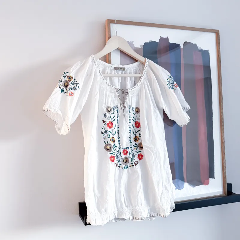 キッズサイズのフィンランドフォークロアブラウス。胸元の刺繍柄の花柄が北欧伝統柄でキュートです。小柄な方なら大人でも大丈夫。