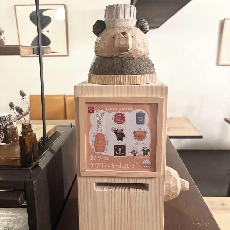 手紙舎おやつのアイコン、くまのアクリルキーホルダーガチャガチャです。高旗将雄さん作の木製マシンをぜひ体験してください！