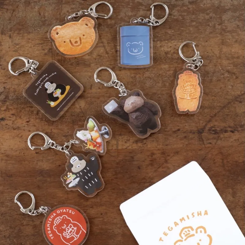 木彫りのくまガチャガチャで販売している7種類のキーホルダーは手紙舎おやつの歴代クッキー缶がモチーフです。