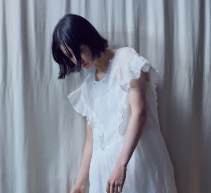 光と影を淡く映すラッフルドレス。